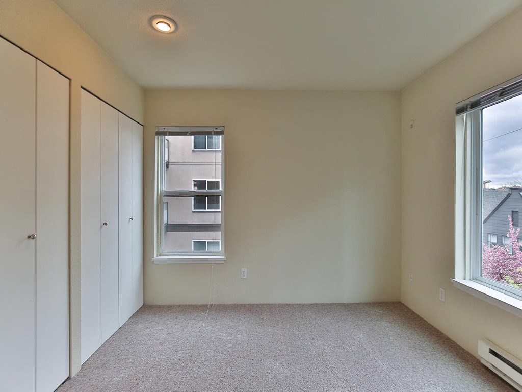 an empty room with a window and a closet