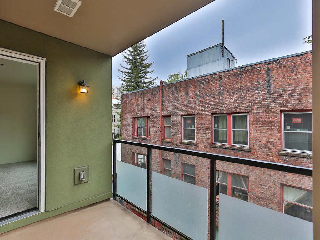 a balcony with a brick building in the background