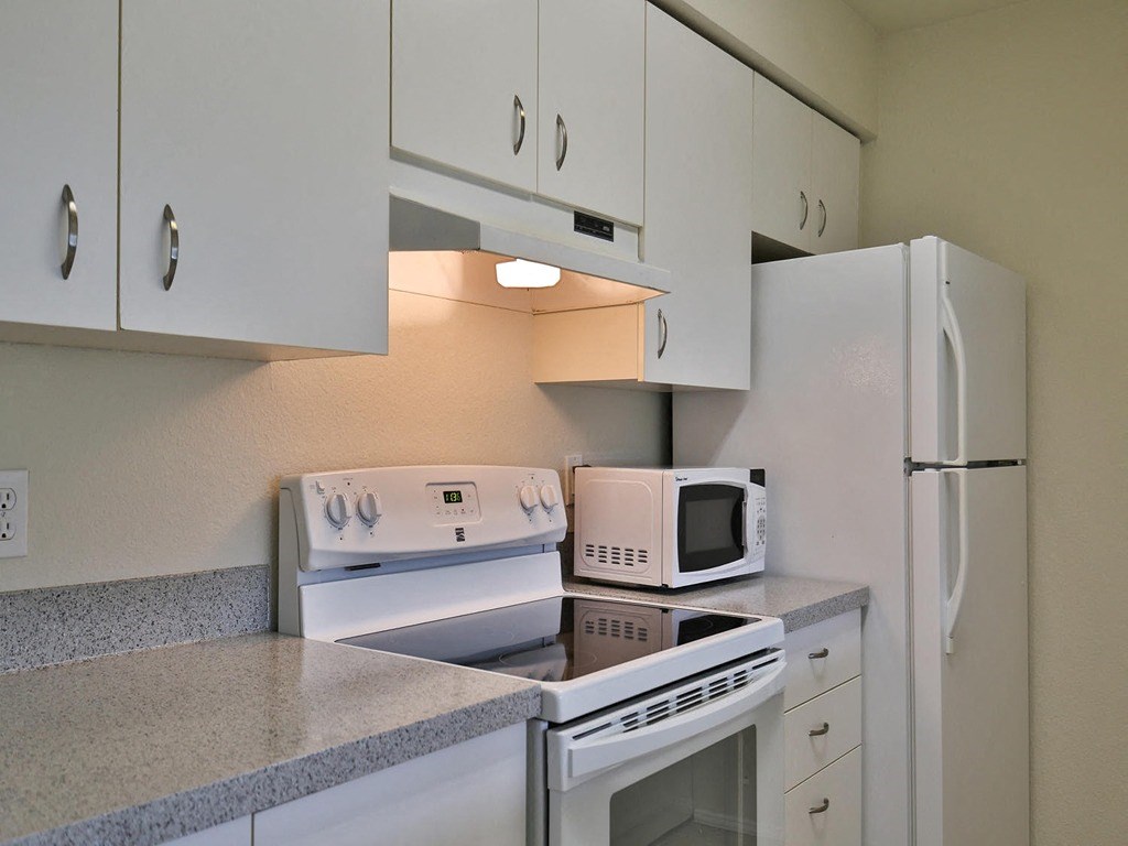 a kitchen with white appliances and white cabinets