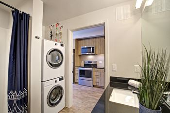 A modern laundry room with a washer and dryer stacked on top of each other.