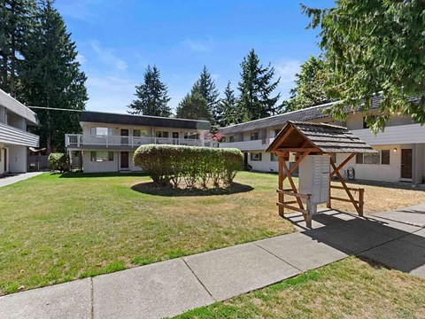 A sunny day at a residential area with a small building in the foreground.