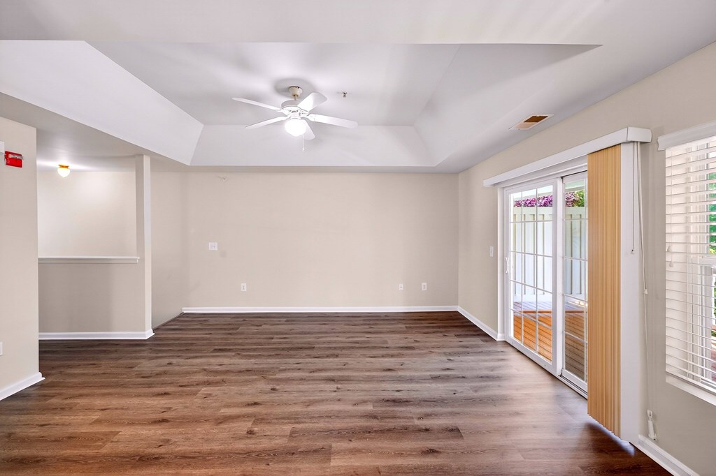 A room with wooden flooring and a ceiling fan.