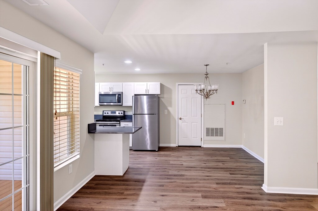 A kitchen with a refrigerator, microwave, and oven.
