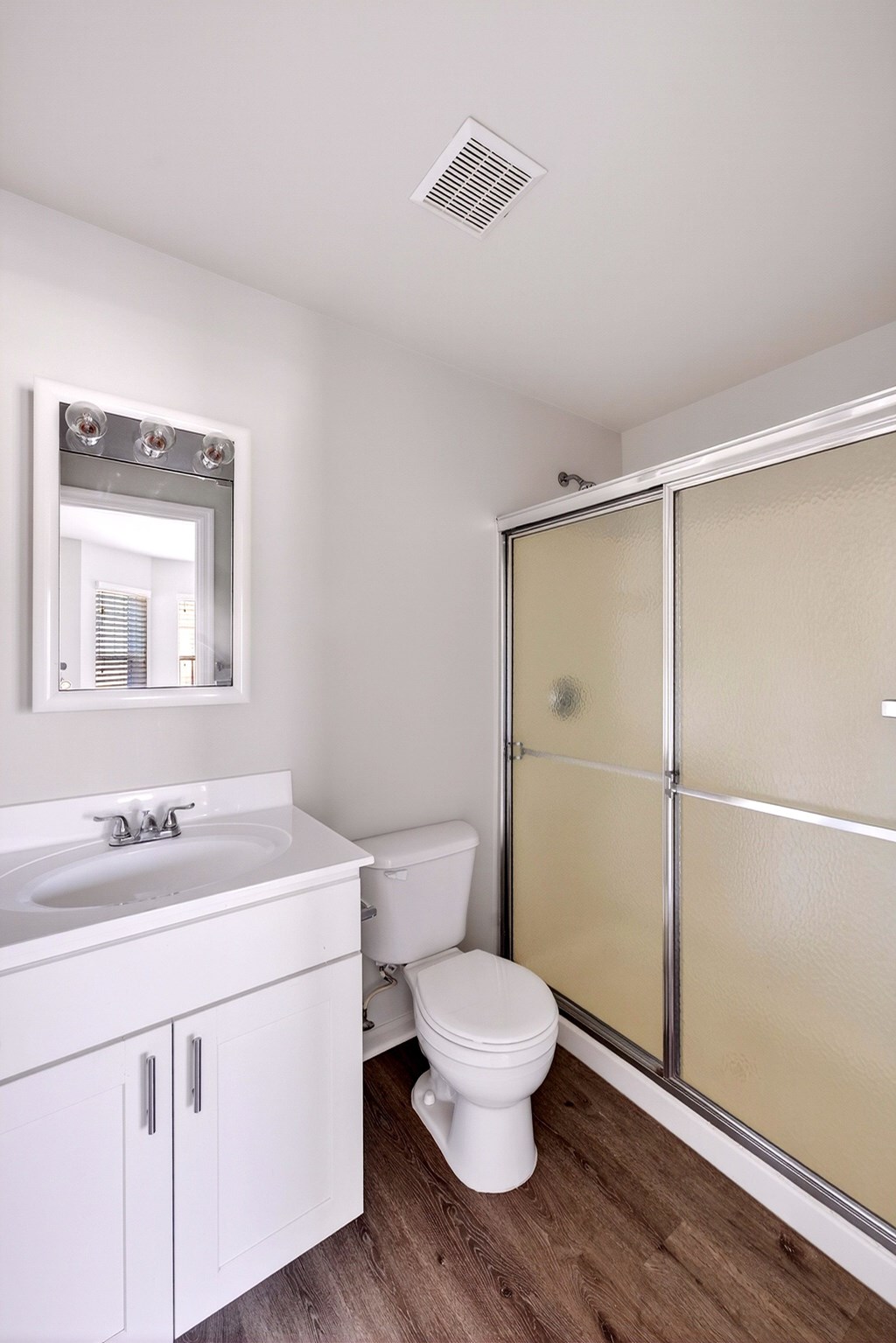 A white toilet sits next to a sink in a small bathroom.