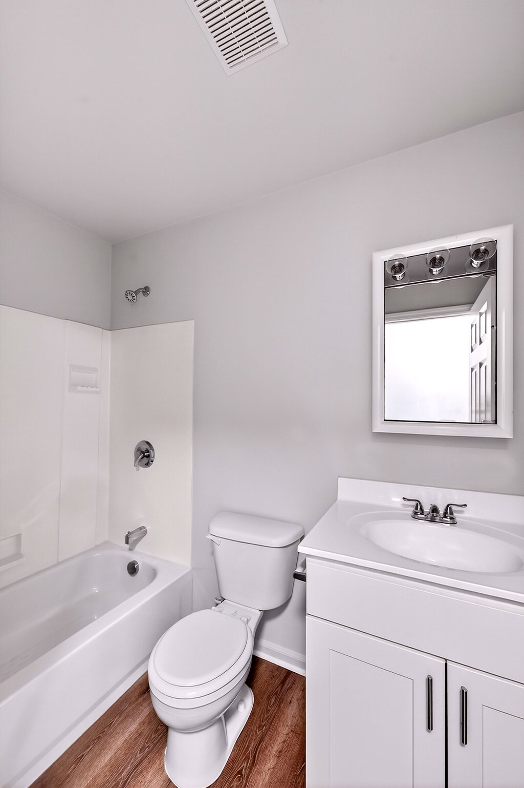 A white bathroom with a toilet, sink, and bathtub.