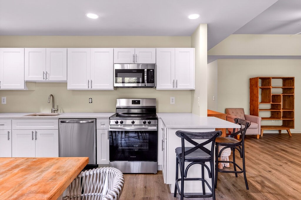 A kitchen with a wooden table and bar stools.