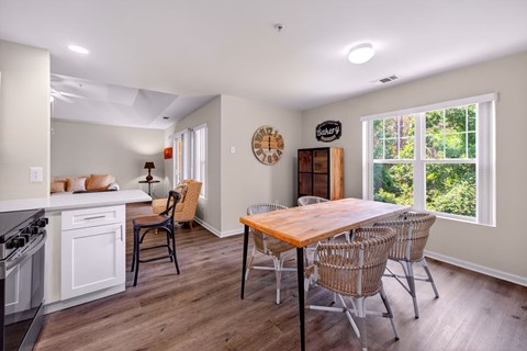 A kitchen with a table and chairs in front of a window.