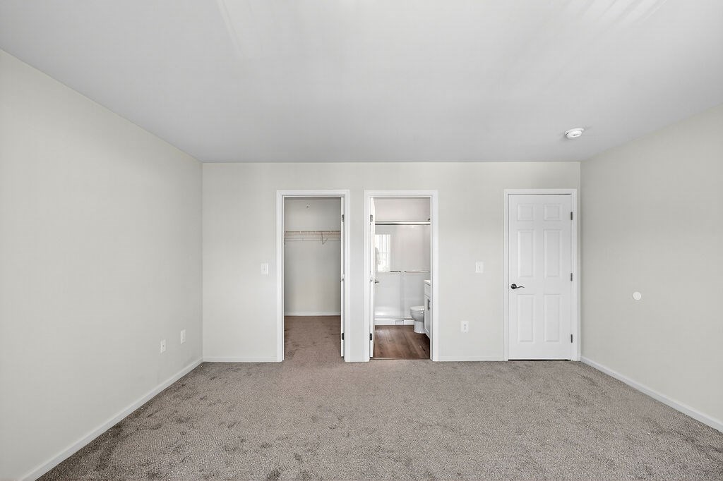 A room with a carpeted floor and white walls.