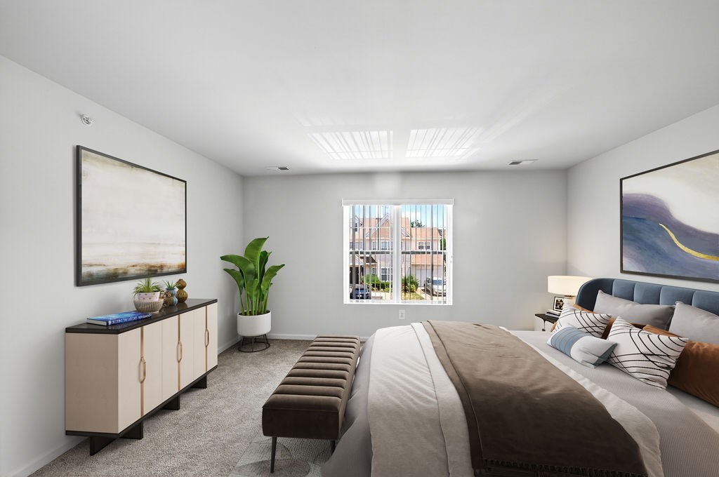 A bedroom with a large bed, a bench, and a window overlooking a cityscape.