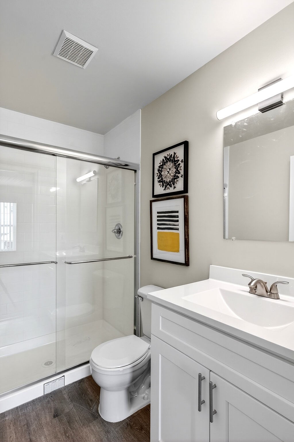 A white toilet sits in a bathroom next to a sink.