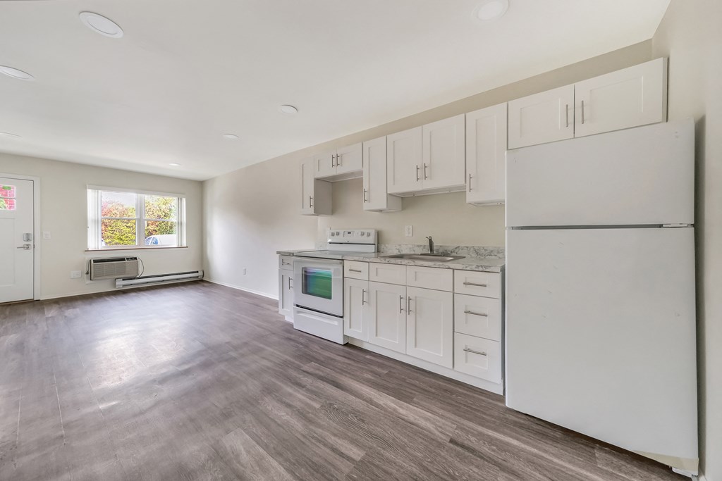 Kitchen and living area with wooden floor at Amity Senior, Amityville, NY, 11701