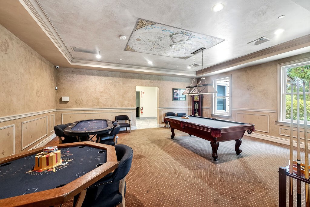 A room with a pool table and a billiard table.