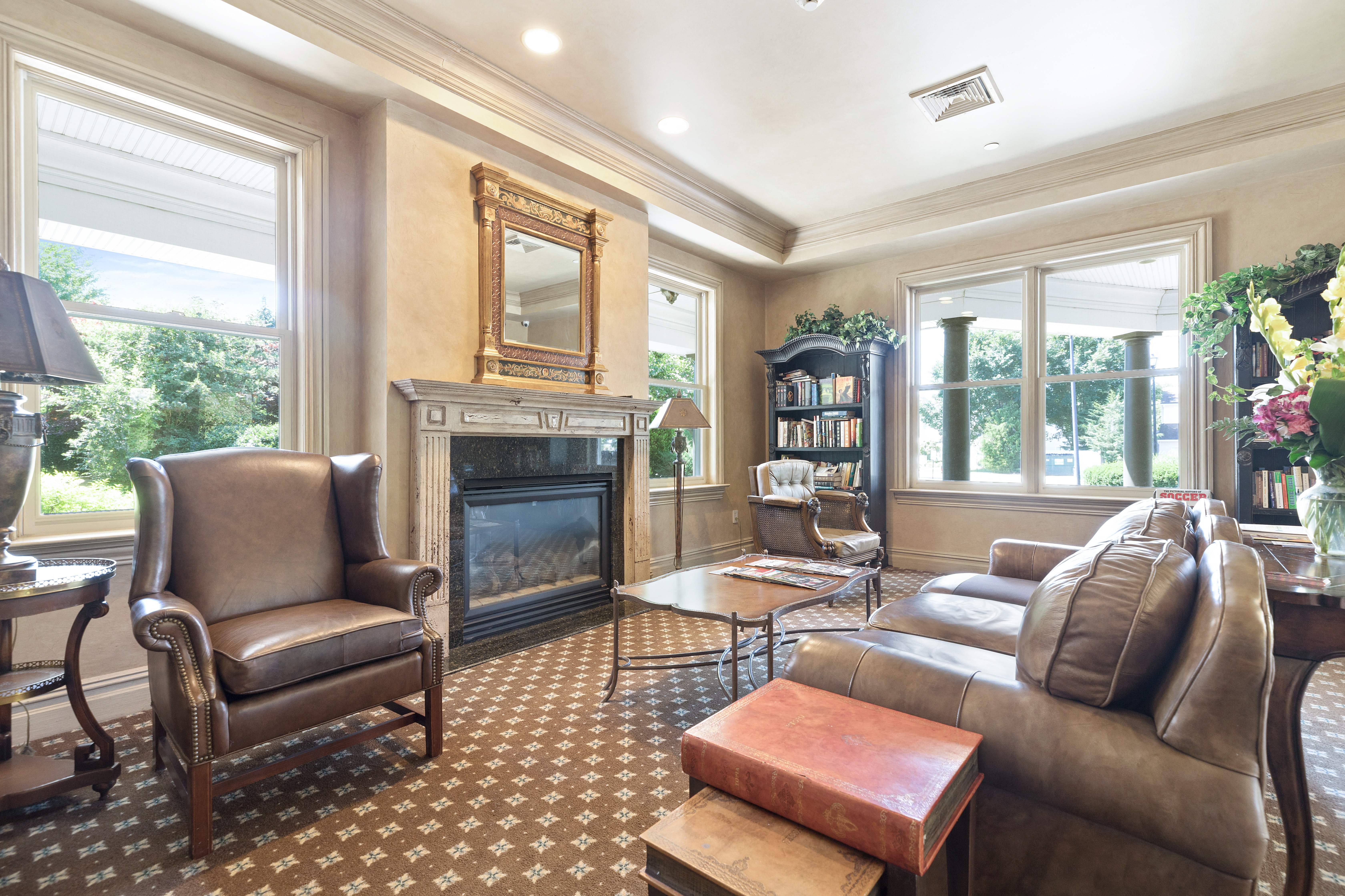 a living room with a fireplace and leather furniture