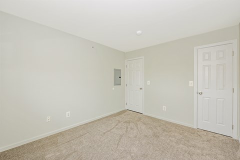 a bedroom with a carpeted floor and a white door  at Platt Gardens, West Babylon, NY