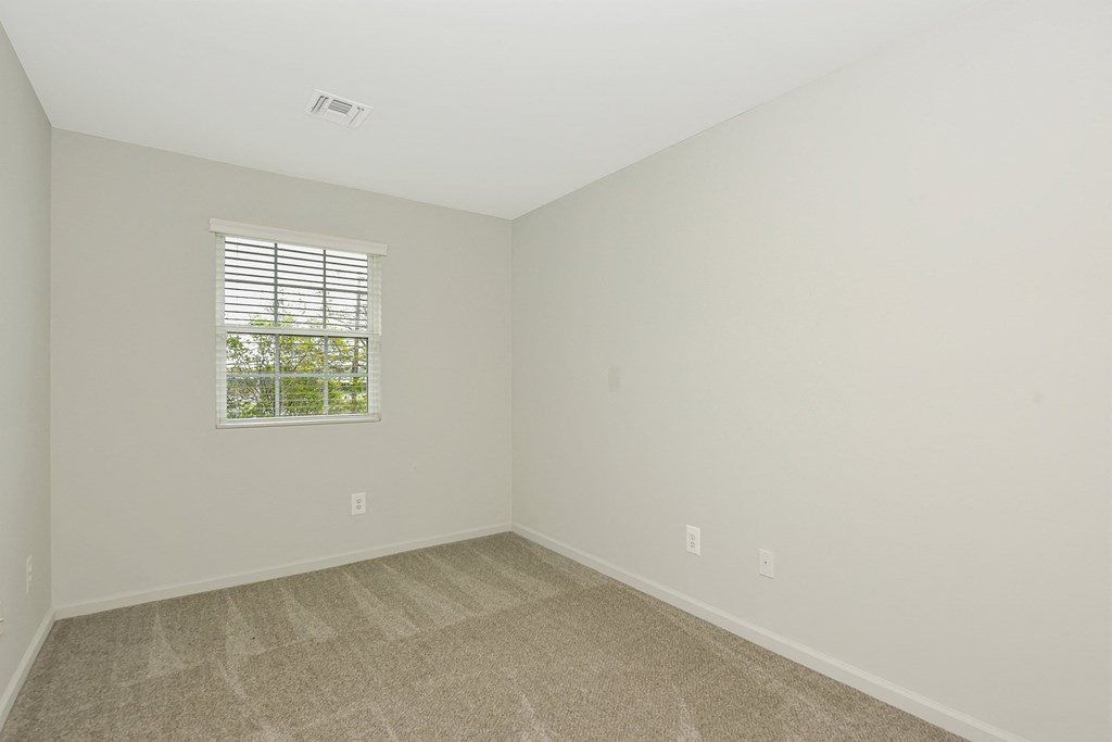 a bedroom with white walls and a window  at Platt Gardens, West Babylon