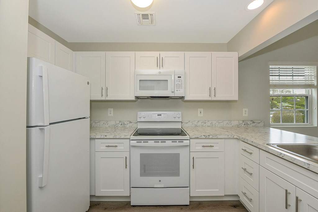 a kitchen with white cabinets and white appliances  at Platt Gardens, West Babylon, NY, 11704