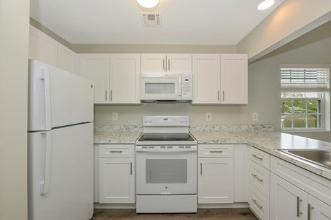 a kitchen with white cabinets and white appliances  at Platt Gardens, West Babylon, NY, 11704