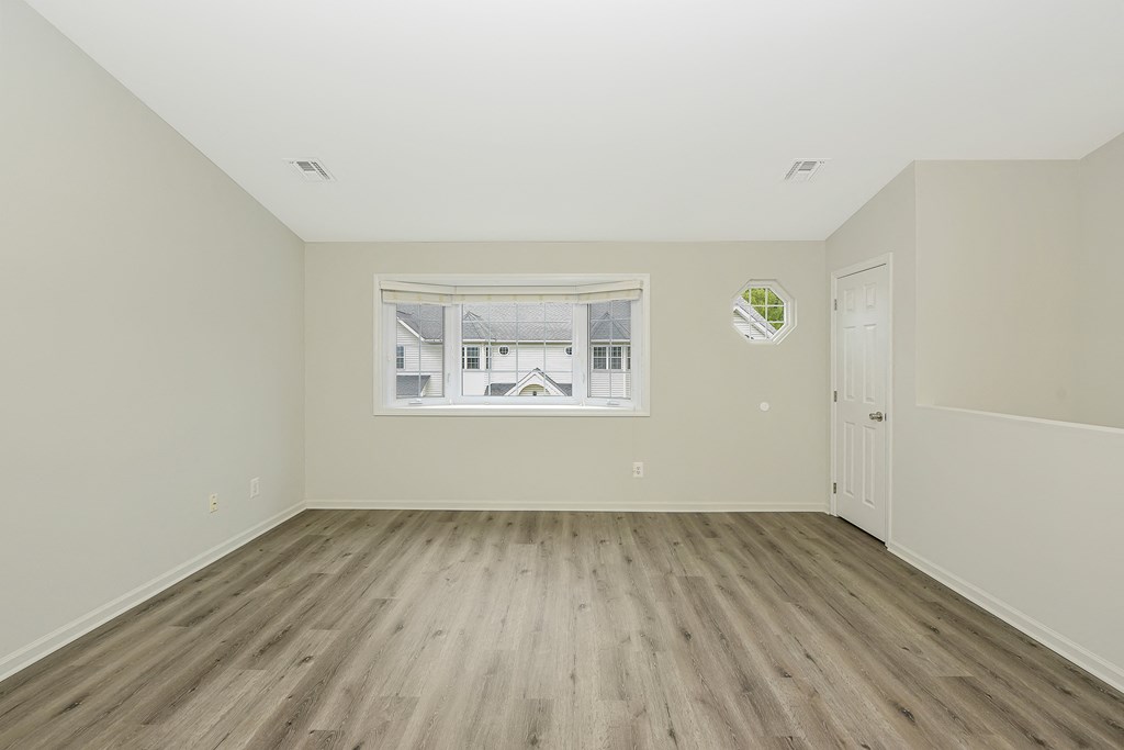 a bedroom with hardwood floors and a large window  at Platt Gardens, West Babylon, NY