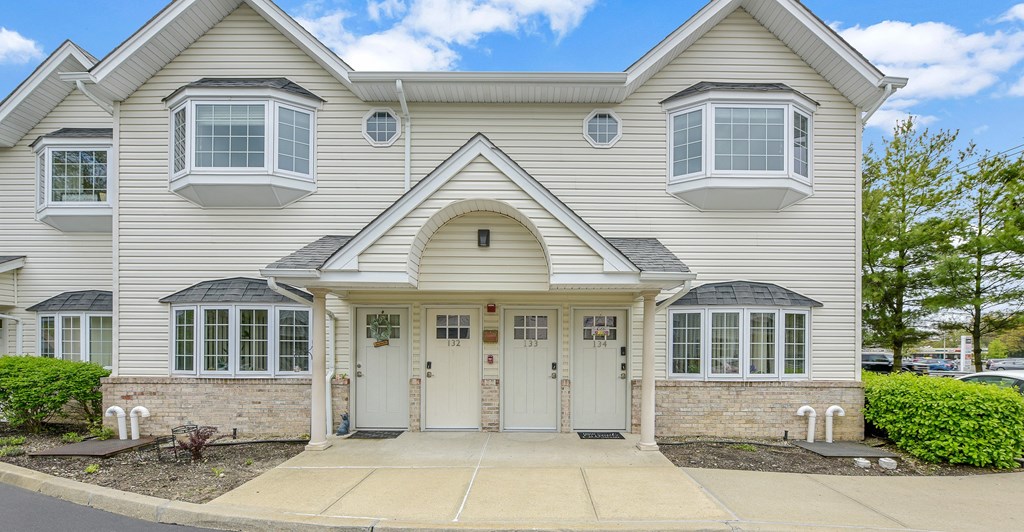 a large white house with two dormer windows and a white front door  at Platt Gardens, West Babylon