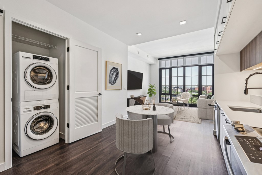 A modern laundry room with a washer and dryer built into the cabinetry.