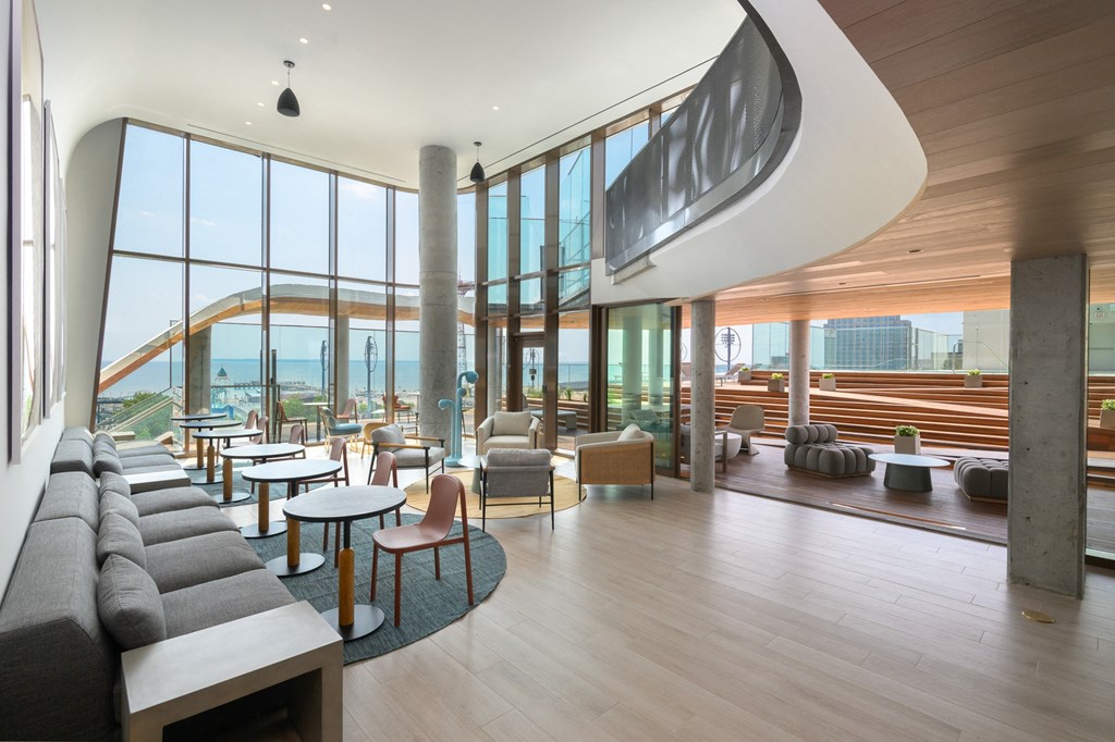 a lounge area with couches and tables and floor to ceiling windows