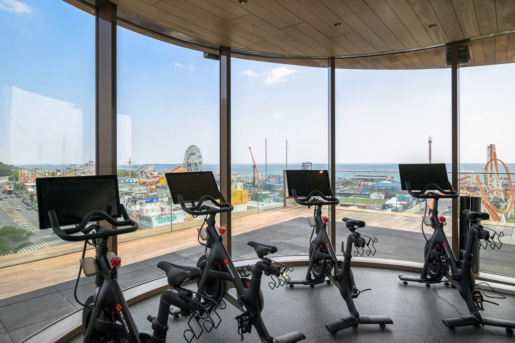 a group of spin bikes in a gym with a view of the city