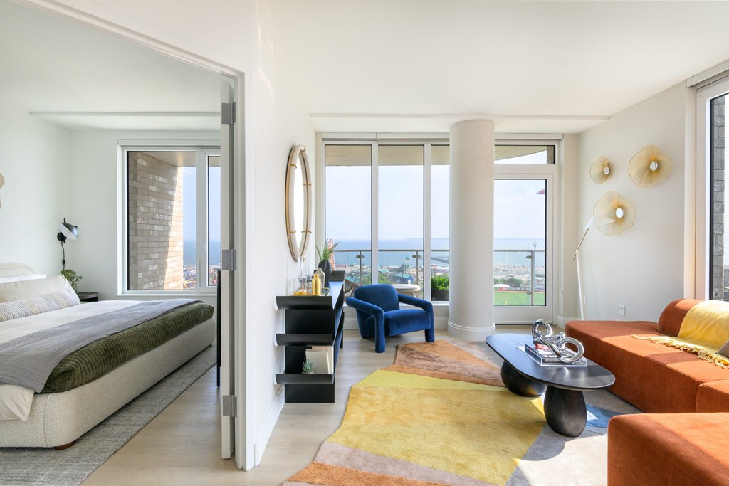 a bedroom with a bed and a living room with a couch and a table