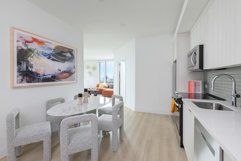 a kitchen and dining room with a white table and chairs