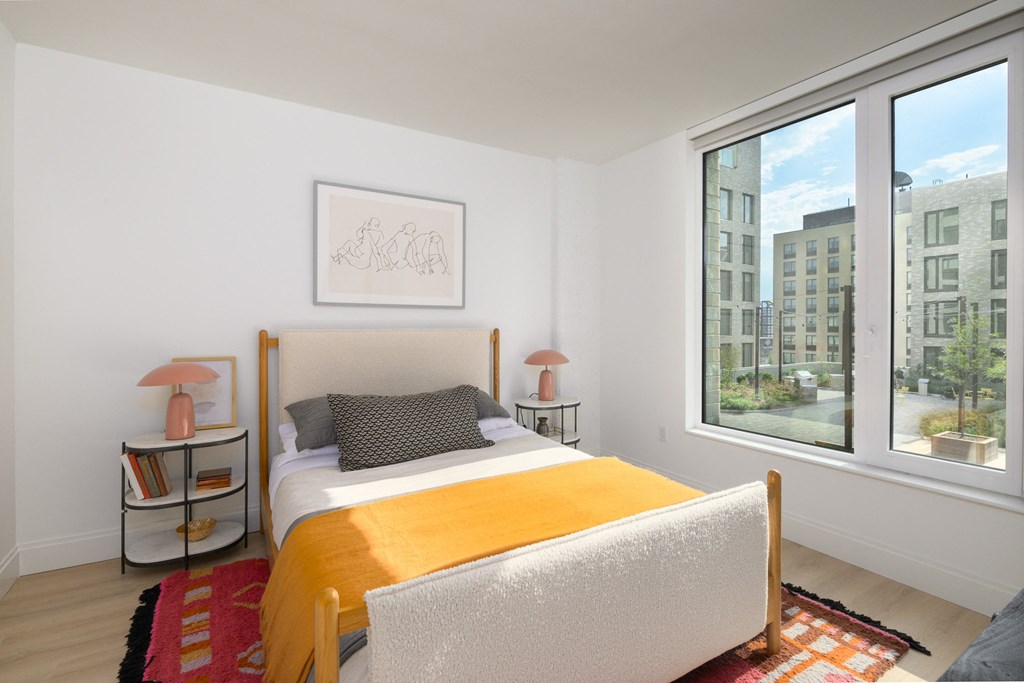 a bedroom with a bed and a large window