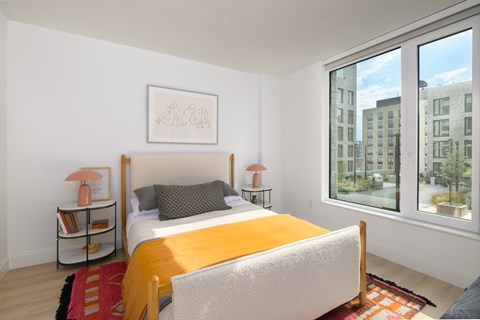 a bedroom with a bed and a large window