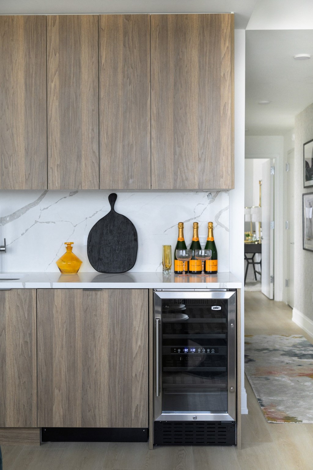 a kitchen with wooden cabinets and a counter with bottles of alcohol on it