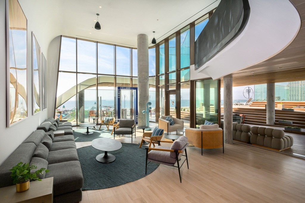 a living room with couches and chairs and a view of the city