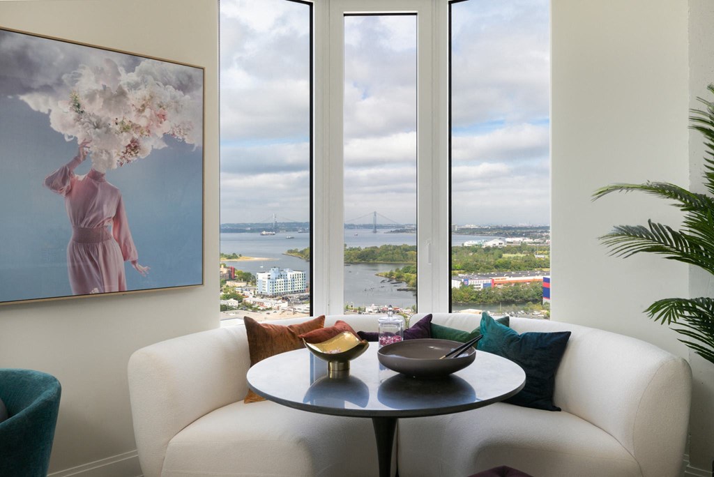 a living room with a white couch and a table and a view of the water