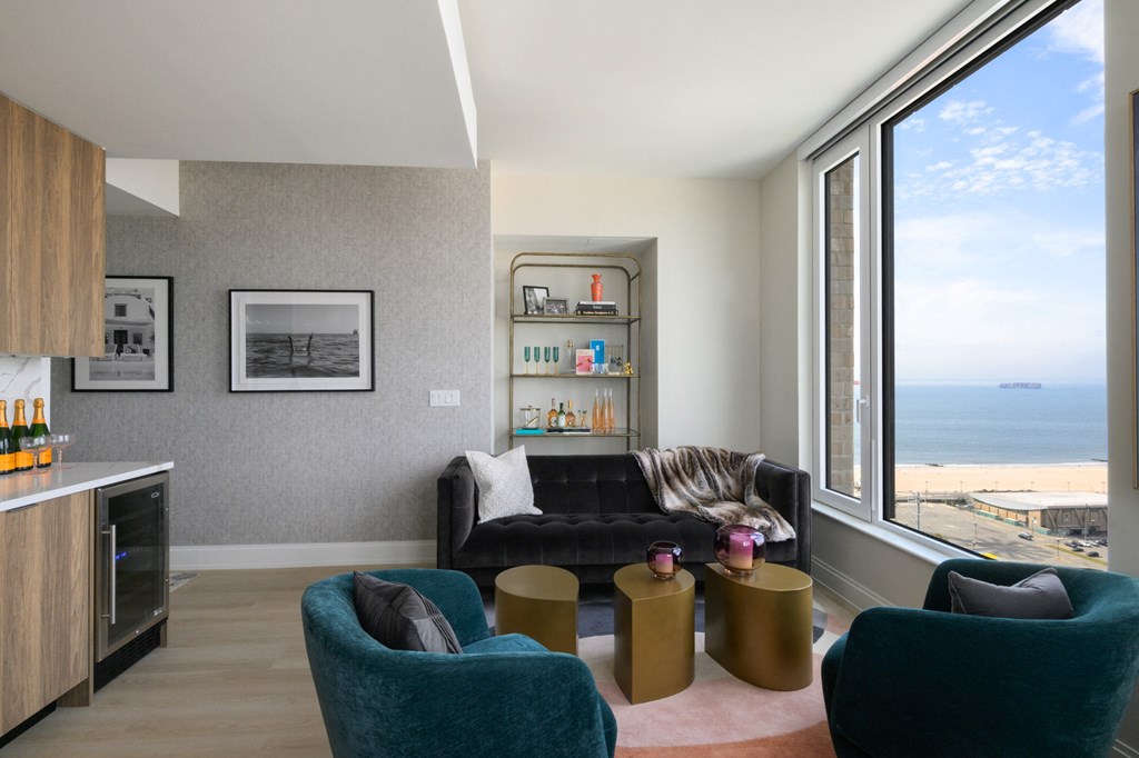 a living room with a large window overlooking the ocean