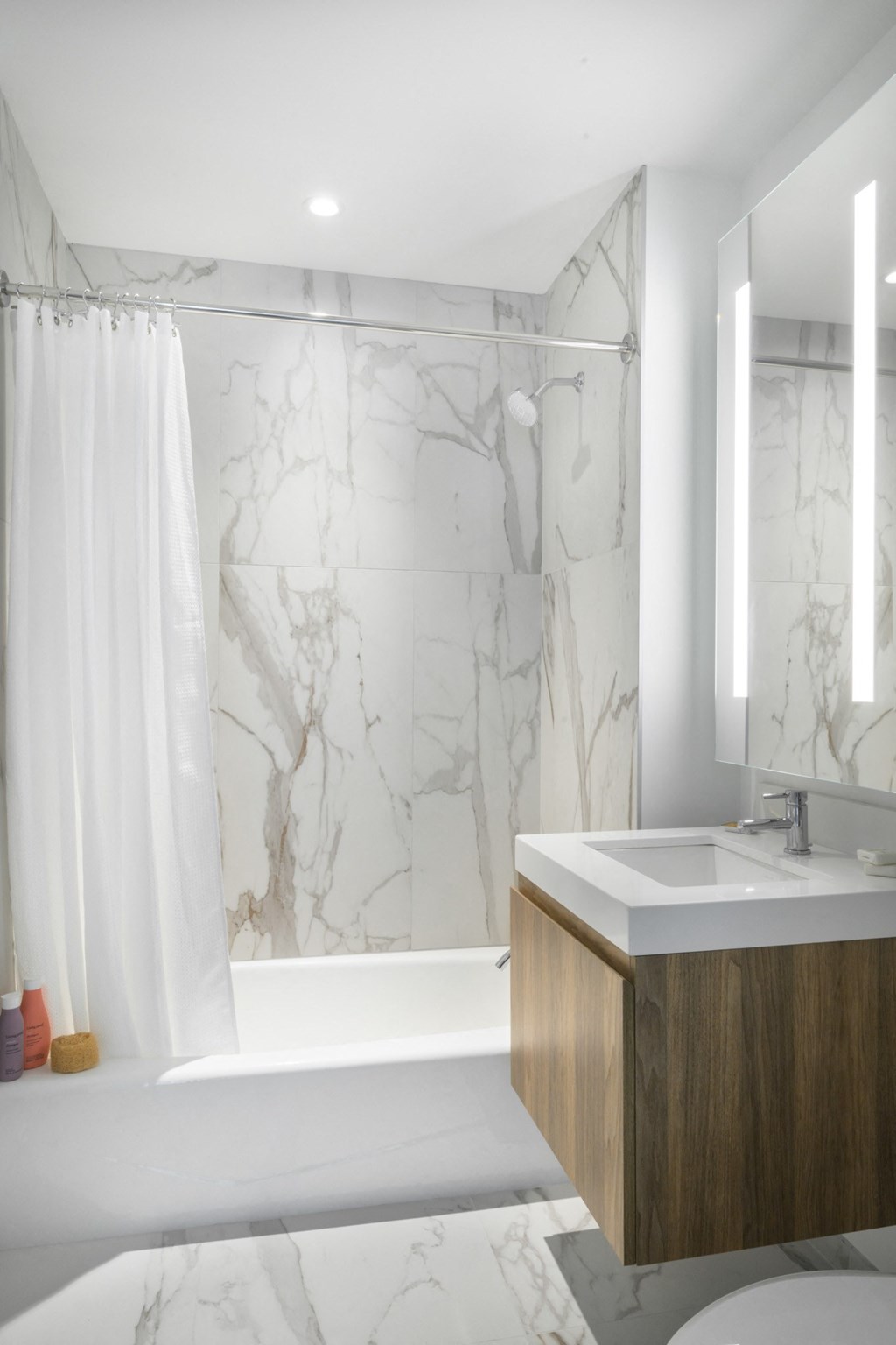 a marble bathroom with a sink and tub and a shower
