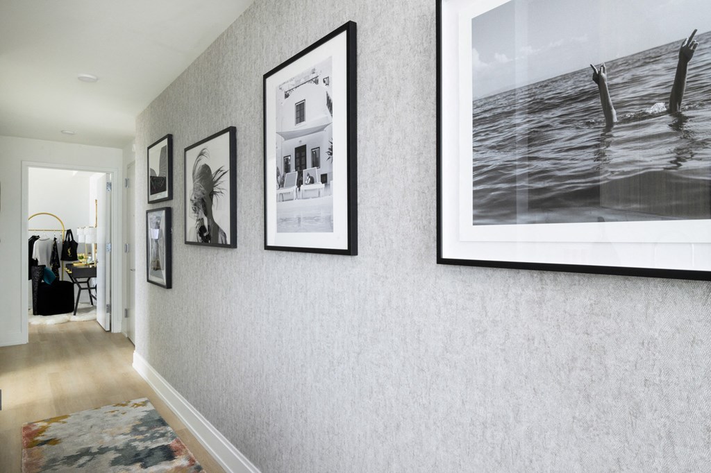 a hallway with pictures on the wall and a rug