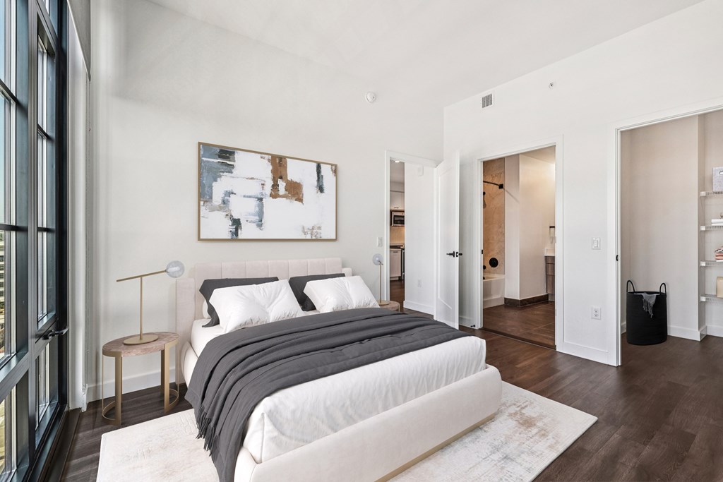 A bedroom with a large bed and a painting on the wall.