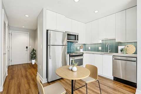 A modern kitchen with a table and chairs.