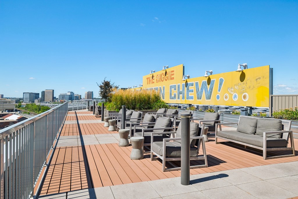 A rooftop patio with chairs and a yellow sign that says "The Bistro".