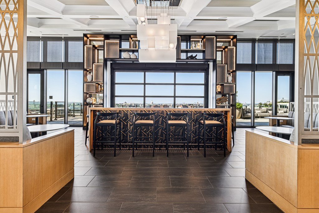 A long table with chairs is in the middle of a room with a large window.