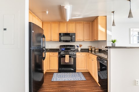 A kitchen with wooden cabinets and black appliances.