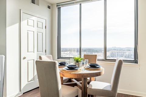 A dining room with a table set for two and a view of the city.