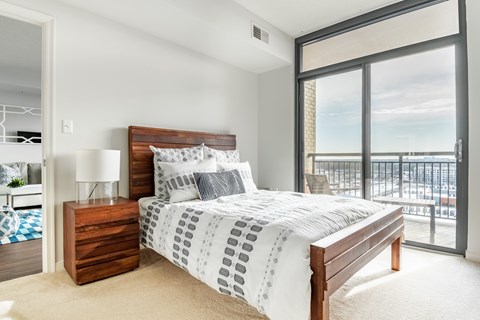 A bedroom with a large bed and a view of the city.