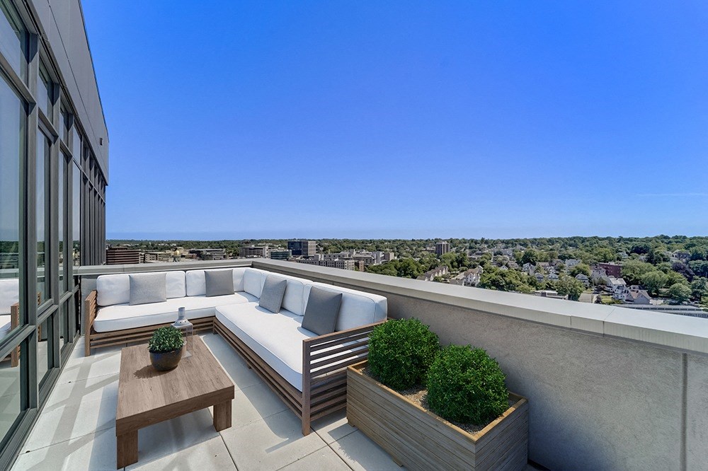 penthouse outdoor balcony with a couch and a tableat Continuum, White Plains, NY