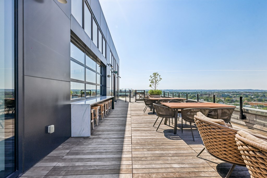 A patio with a table and chairs overlooking a cityscape.