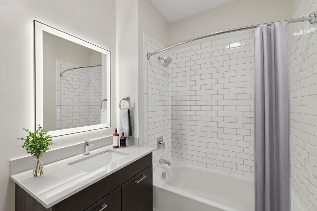 A bathroom with a white sink and a white bathtub.