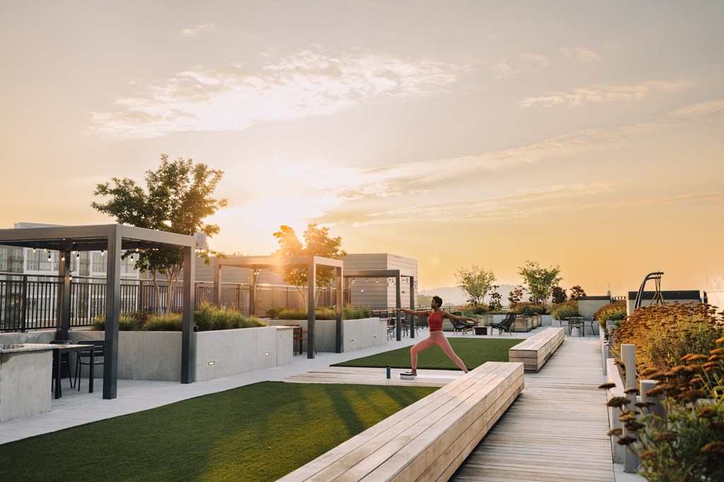 a woman runs across a grassy area on a roof