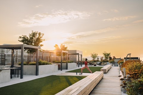 a woman runs across a grassy area on a roof