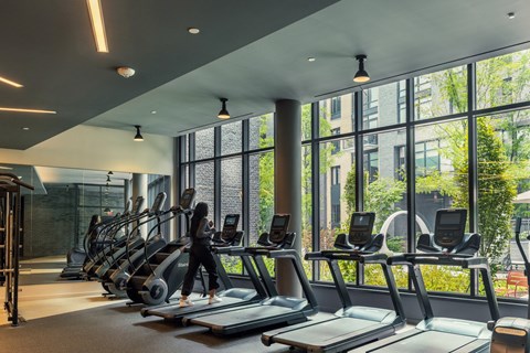 a woman walking on a treadmill in a gym