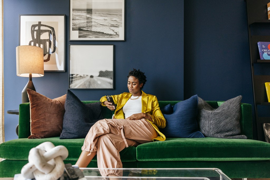 a woman sitting on a couch looking at her cell phone